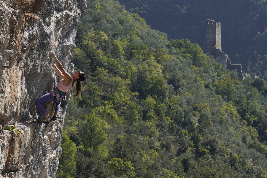 Arrampicata su una falesia di Ferentillo, con il borgo di Precetto sullo sfondo